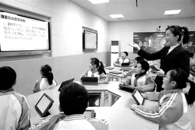 Li Qiufang, a teacher of Qingnian Road Primary School in Tongchuan City, is taking a math class. The multi-directional display screen is connected with a tablet computer, which realizes the optimization of students' classroom presentation. Photo by Meng Qingyi